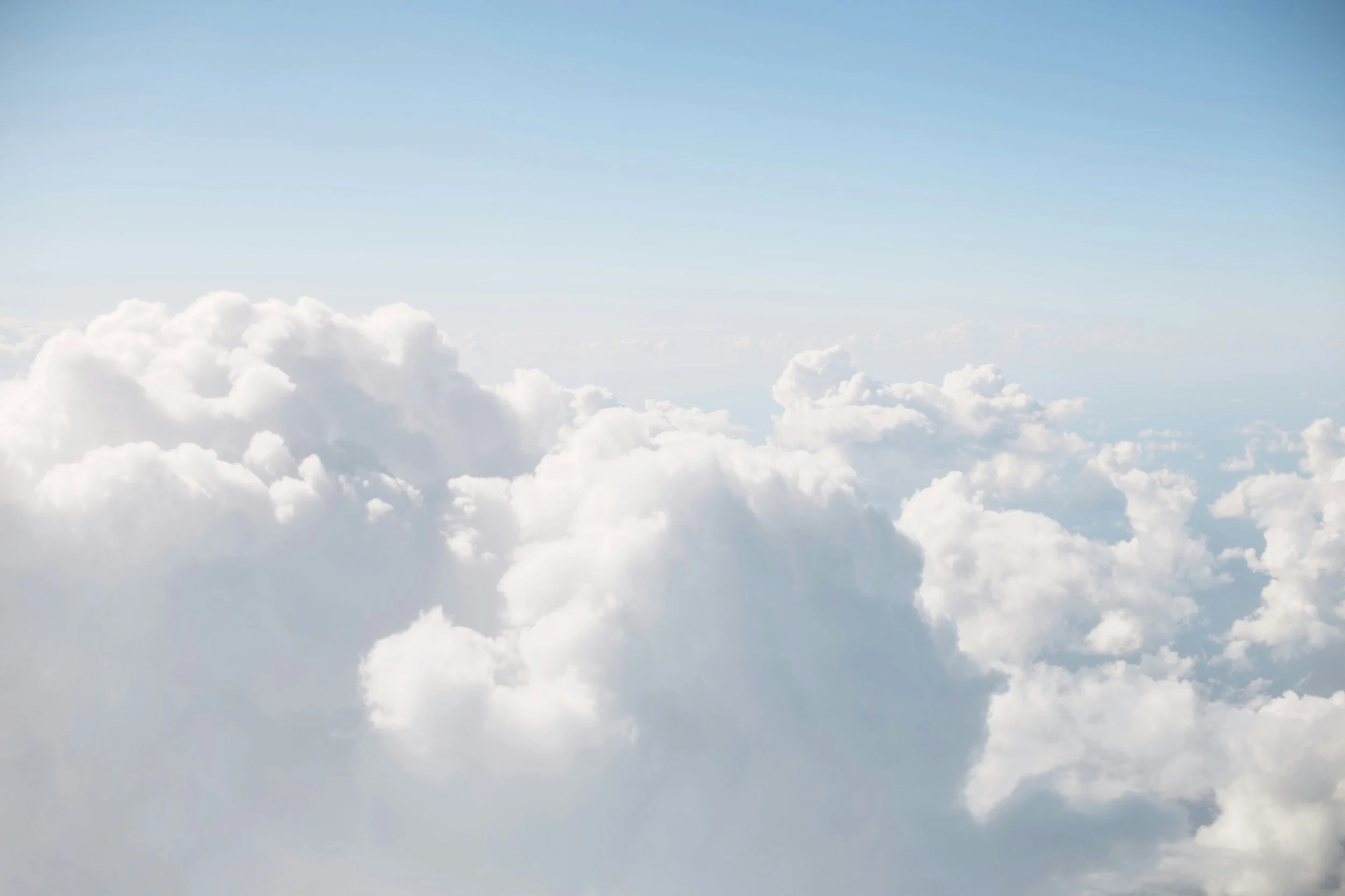 Soft daylight clouds against pale blue sky
